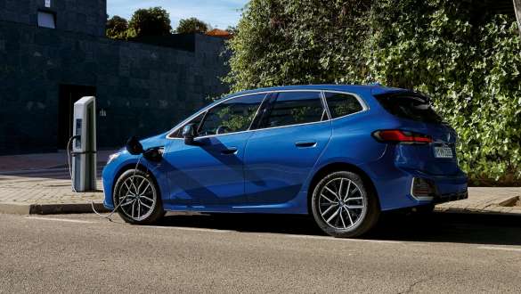 BMW 2 серії Active Tourer 230e плагін-гібрид U06 2021 припаркований на зарядній станції BMW 2 серії Active Tourer 230e плагін-гібрид U06 2021 M у кольорі Portimao Blue металік припаркований на зарядній станції, вид збоку
