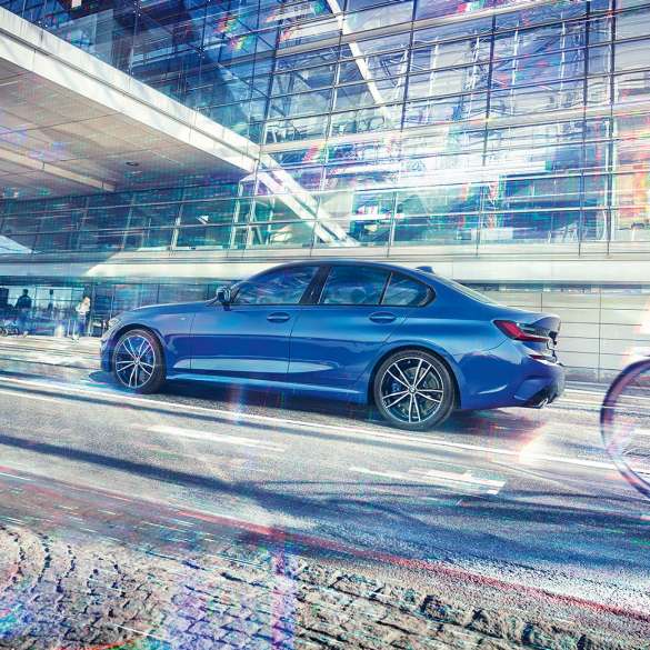BMW 3 серії Седан, вид збоку. Боковий знімок седана BMW 3 серії в день перед скляним будівлею.