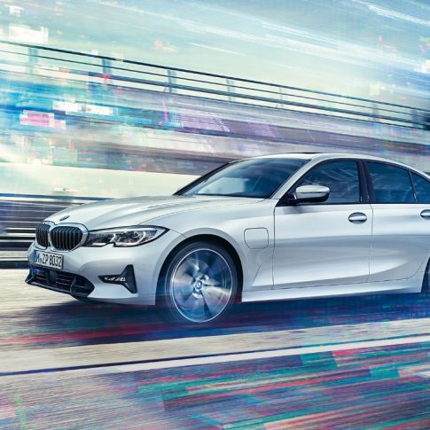 BMW 3 серії Седан, вид збоку седана BMW 3 серії 330е в русі. Вид збоку седана BMW 3 серії 330е в русі на міському тлі.