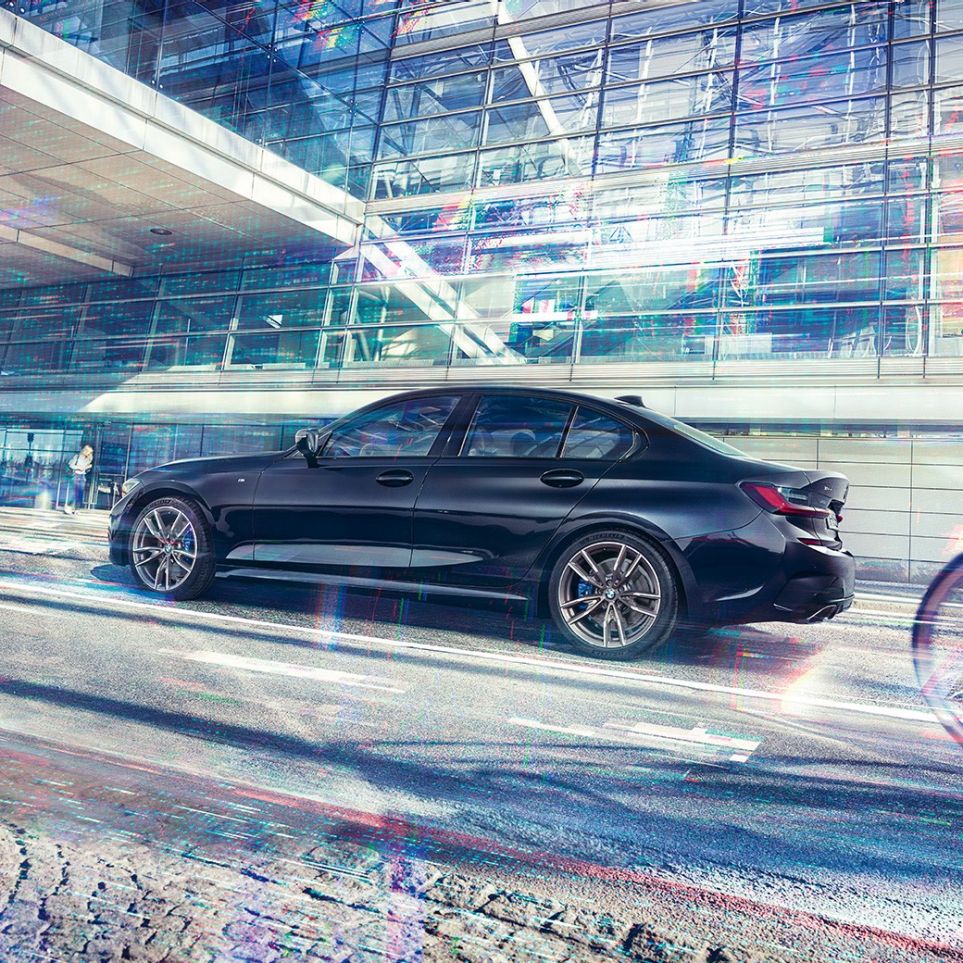 BMW 3 серії Седан, BMW M340i xDrive. Вид збоку на BMW M340i xDrive перед міською будівлею.