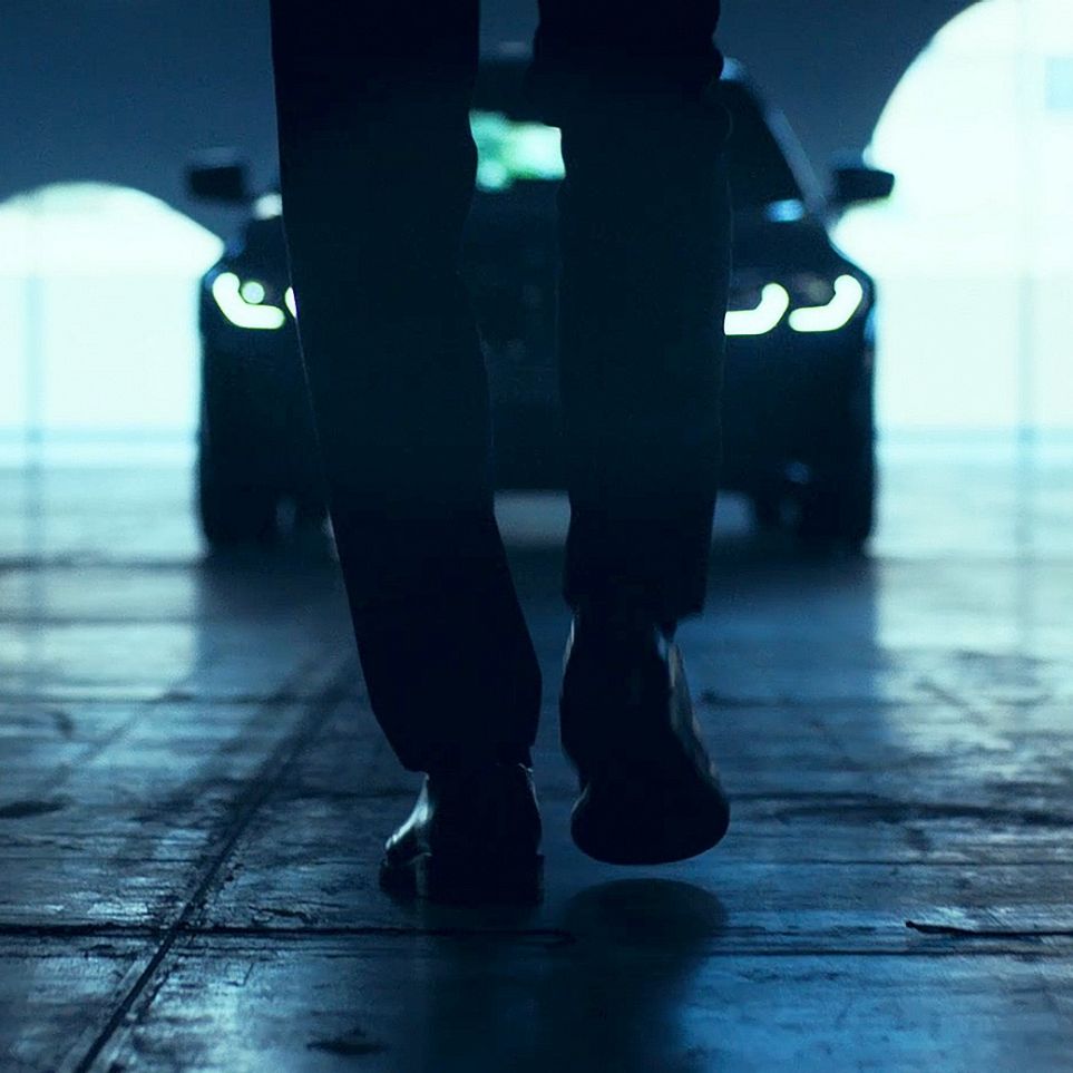 BMW 3 серії Седан, передня частина. Вид ззаду людини перед седаном BMW 3 серії на дорозі.
