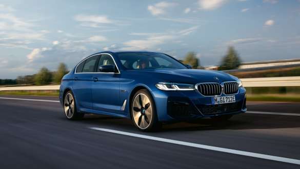Плагін-гібрид BMW 5 серії Седан 2021 G30 вид спереду у русі Плагін-гібрид BMW 5 серії Седан 2021 G30 вид спереду на три чверті в русі на вулиці