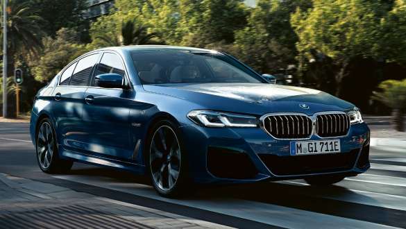 Седан BMW 5 серії G30 вигляд спереду на три чверті Седан BMW 5 серії G30 Facelift 2020 у кольорі Phytonic Blue вигляд спереду на три чверті у русі на вулиці