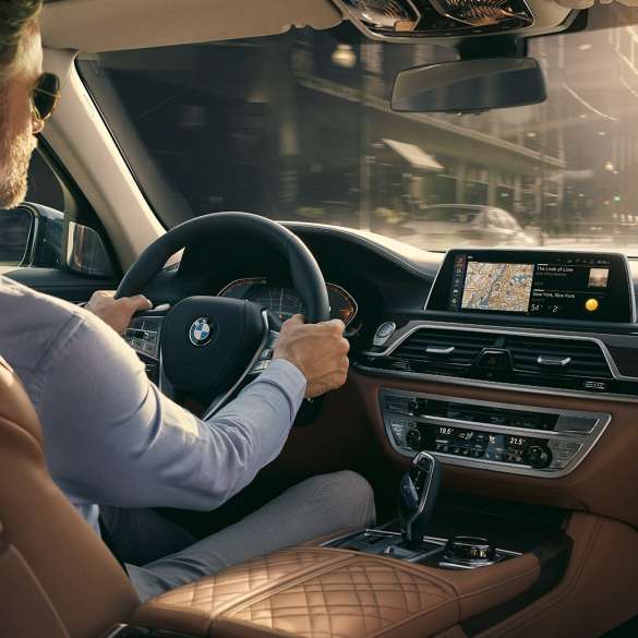 BMW 7 серії Седан: можливості підключення BMW 7 серії Седан: чоловік використовує можливості підключення BMW сидячи в автомобілі