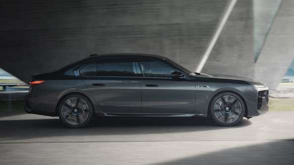 Електричний запас ходу BMW M760e xDrive Седан G70 пакет M Performance Електричний запас ходу BMW M760e xDrive Седан G70 Пакет M Performance BMW Individual двокольорове забарвлення Black Sapphire металік BMW Individual Dravite Grey металік вид збоку в три чверті в русі на вулиці