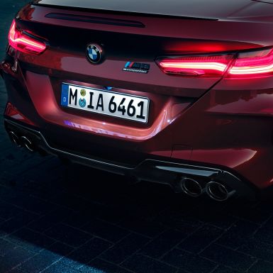 BMW M8 Competition Кабріолет, задня частина. BMW M8 Competition Кабріолет в Motegi Red металік, задня частина зі світлодіодними задніми фарами і значком M8 Competiton.