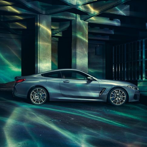 BMW M850i xDrive Coupé, вид збоку. BMW M850i xDrive Coupé в Barcelona Blue металік, вид збоку, перед будівлею.