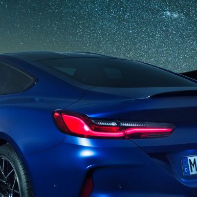 Задній спойлер М BMW M8 Competition Coupé в Marina Bay Blue металік, нічна зйомка плечової частини з заднім спойлером M в карбоні.