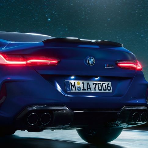 Дифузор М з чорного карбону BMW M8 Competition Coupé в Marina Bay Blue металік, задня частина крупним планом вночі з дифузором M з чорного карбону.