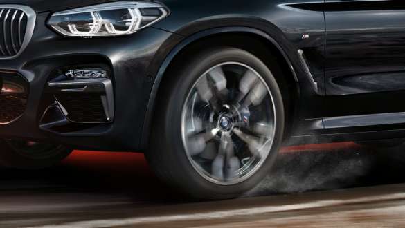 BMW X3 M40i, вид збоку. BMW X3 M40i в Black Sapphire металік, за кермом, екстер'єр, вид збоку з легкосплавними дисками, що крутяться.