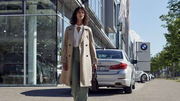 Жінка перед дилерським центром BMW. BMW Service Inclusive Жінка перед дилерським центром BMW.