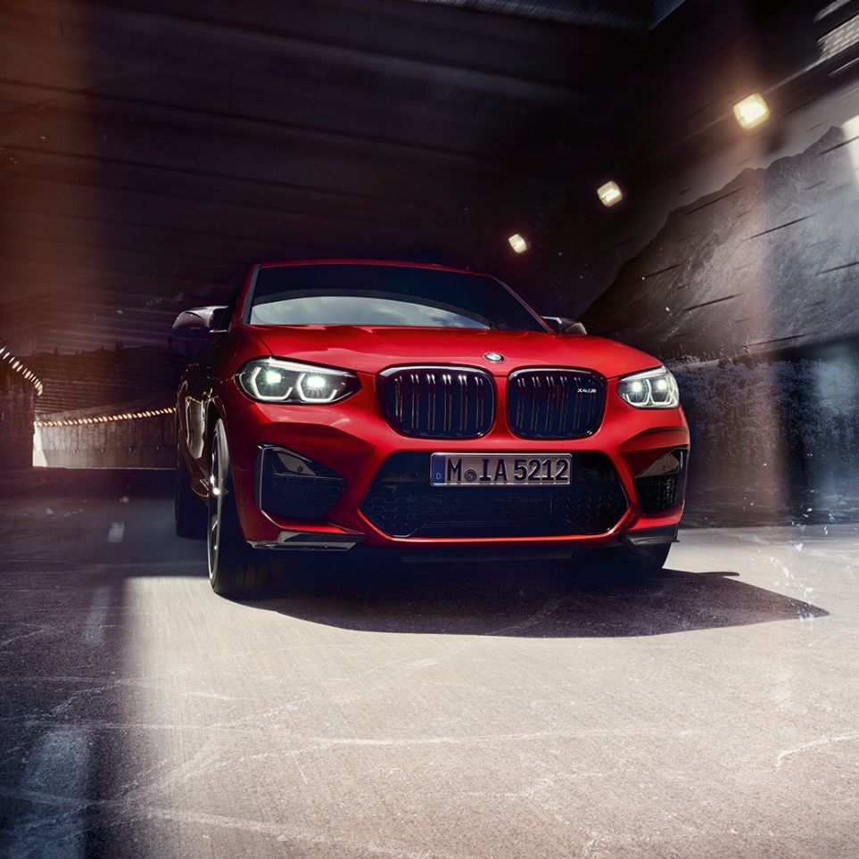 BMW X4 M Competition, вид спереду з поворотом в три чверті. BMW X4 M Competition в Toronto Red металік, екстер'єр, вид спереду з поворотом в три чверті.