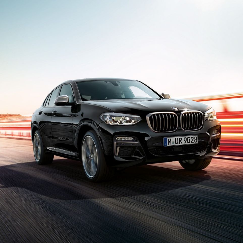 BMW X4 M40i і BMW X4 M40d, вид спереду з поворотом в три чверті. BMW X4 M40i і BMW X4 M40d в Black Sapphire металік, екстер'єр, вид спереду з поворотом в три чверті, ліва сторона зі світловими смужками.
