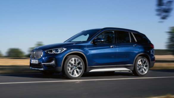 Плагін-гібрид BMW X1 xDrive25e F48 LCI вигляд спереду на три чверті під час їзди Плагін-гібрид BMW X1 xDrive25e F48 LCI вид спереду на три чверті під час їзди вулицею