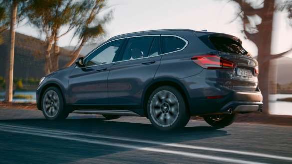 BMW F48 вид ззаду на три чверті BMW X1 F48 LCI вид ззаду на три чверті в русі на тлі гірського пейзажу
