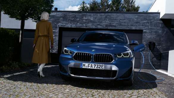 Плагін-гібрид BMW X2 xDrive25e F39, вид спереду на автомобіль перед гаражем Плагін-гібрид BMW X2 xDrive25e F39, вид спереду на автомобіль з моделлю перед гаражем