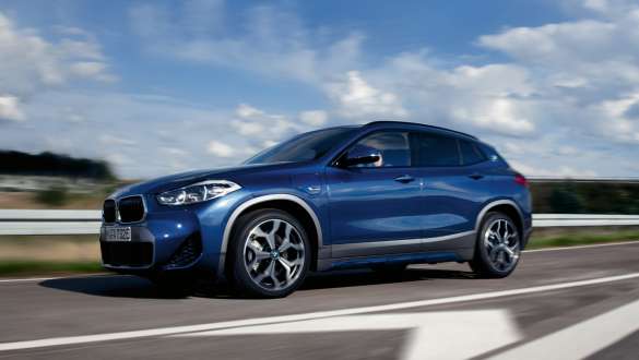 Плагін-гібрид BMW X2 xDrive25e F39, вид на автомобіль збоку з поворотом на три чверті під час руху Плагін-гібрид BMW X2 xDrive25e F39, вид на автомобіль збоку з поворотом на три чверті під час руху на вулиці