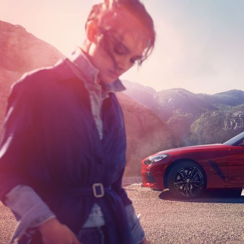 BMW Z4 Родстер перед видом на гори Чоловік та жінка і BMW Z4 Roadster перед видом на гори