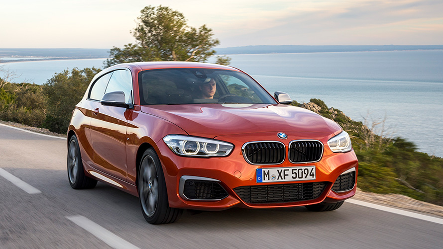 BMW M135i (F21) Три чверті, вид спереду, їзда перед озером і горами BMW M135i (F21) Три чверті, вид спереду, їзда перед озером і горами