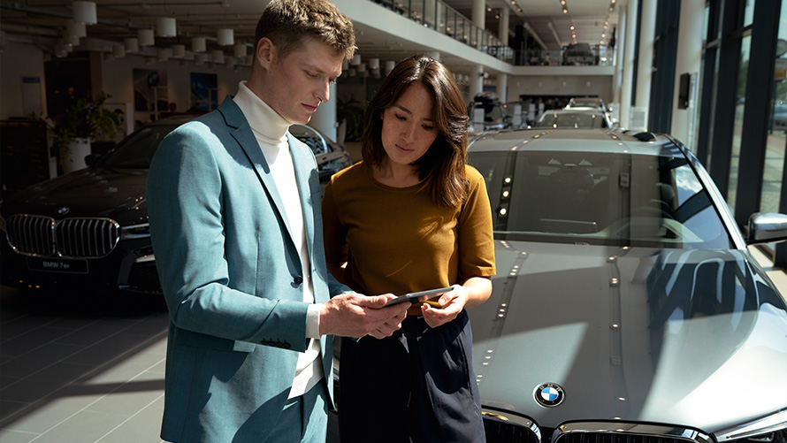 Співробітник сервісного центру BMW консультує клієнтку. Співробітник сервісного центру BMW консультує клієнтку.