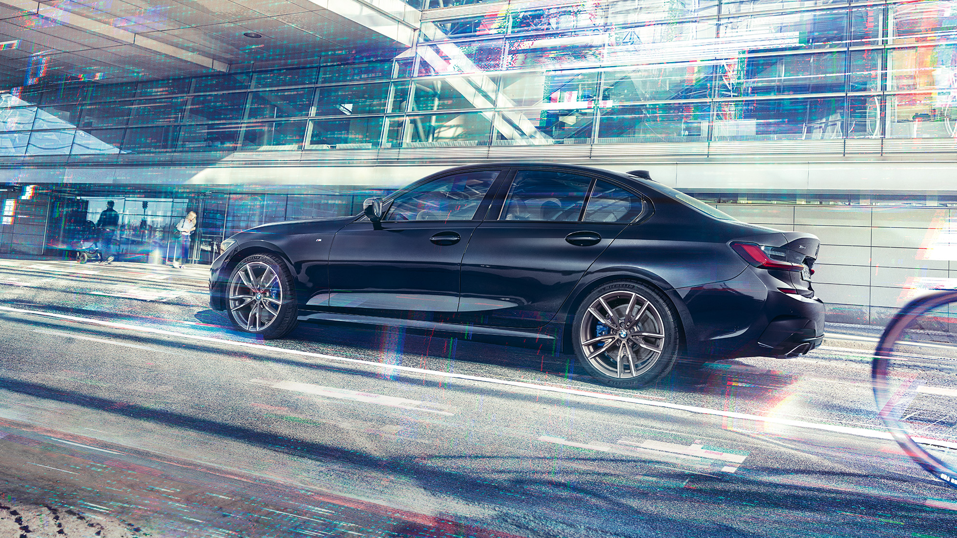 BMW 3 серії Седан, BMW M340i xDrive. Вид збоку на BMW M340i xDrive перед міською будівлею.