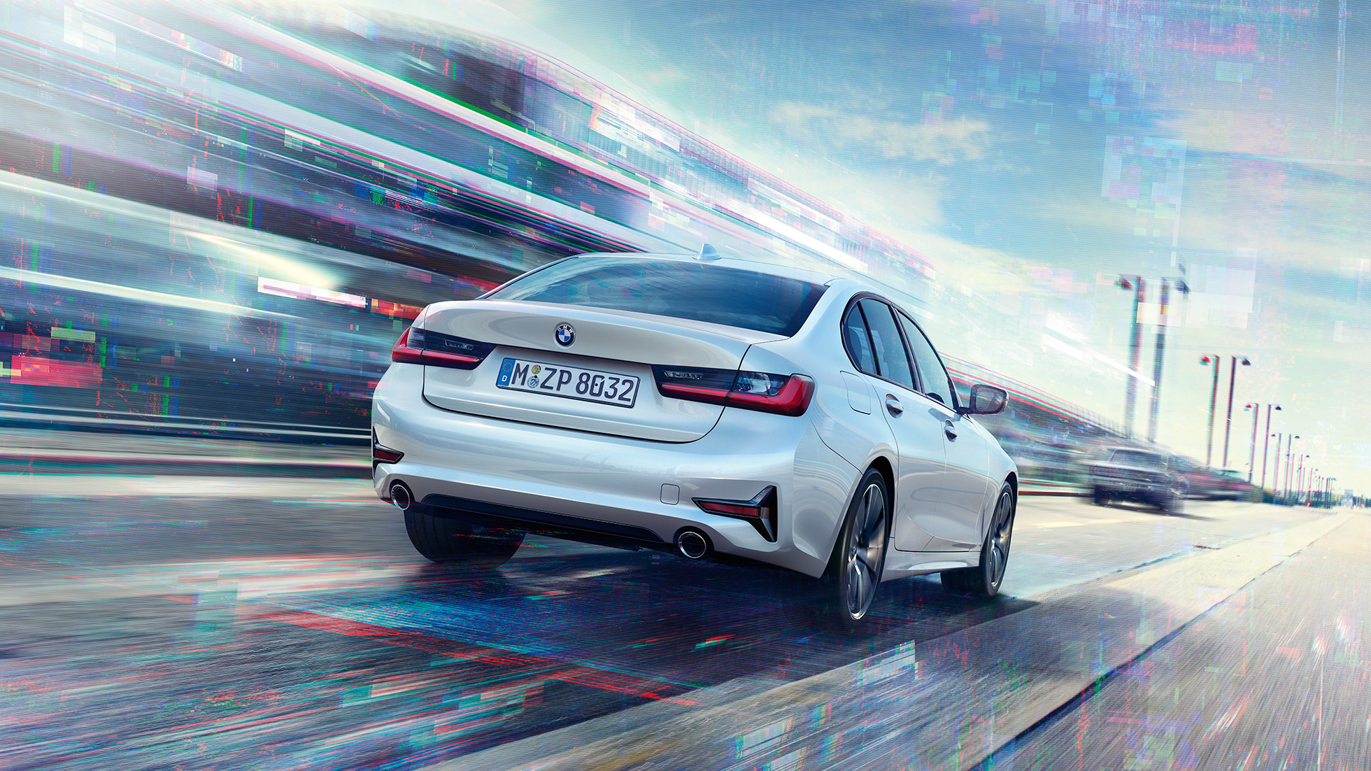 BMW 3 серії Седан 330e, вид ззаду. Вид ззаду BMW 3 серії Седан 330е в русі з поворотом в три чверті.