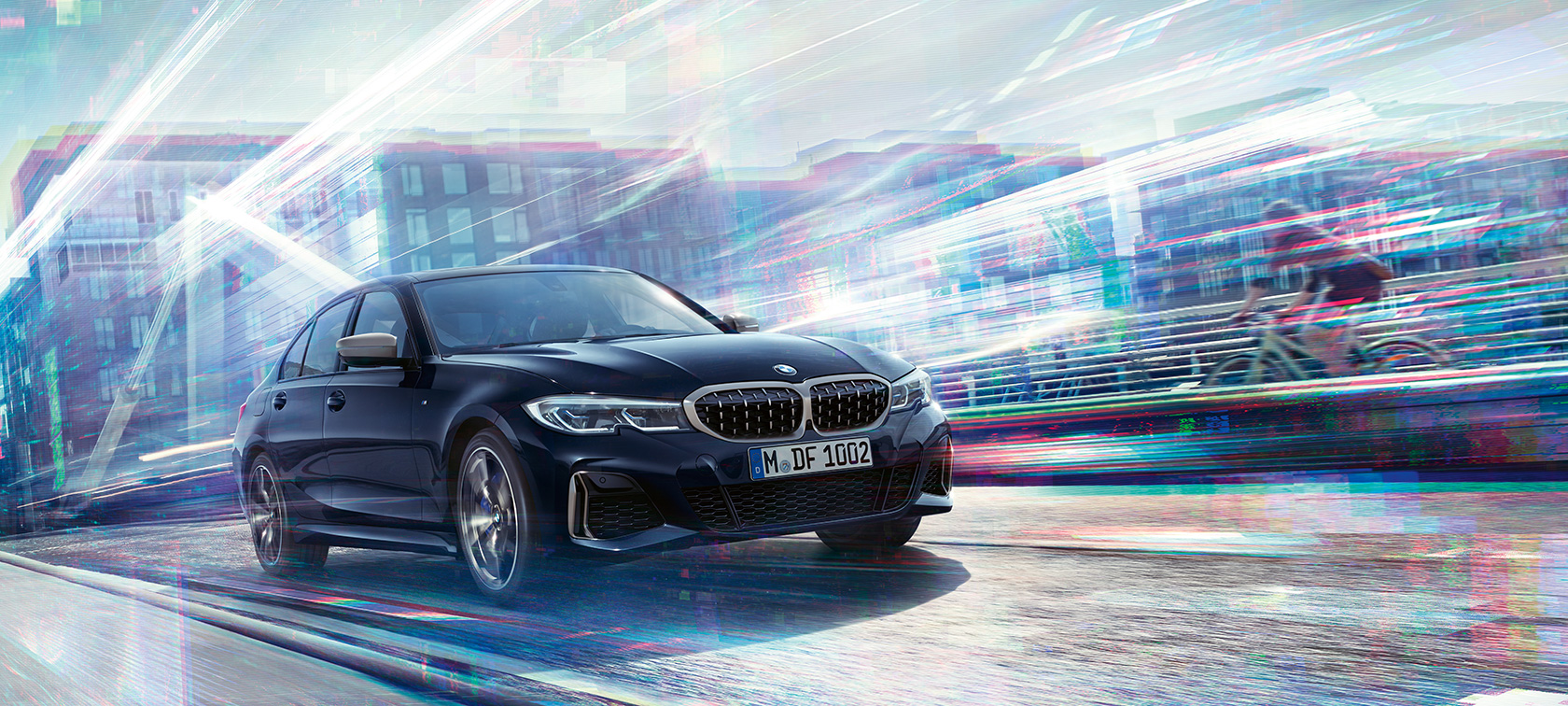 BMW 3 серії Седан, BMW M340i xDrive. Вид збоку BMW M340i xDrive з поворотом в три чверті, що рухається на міському тлі.