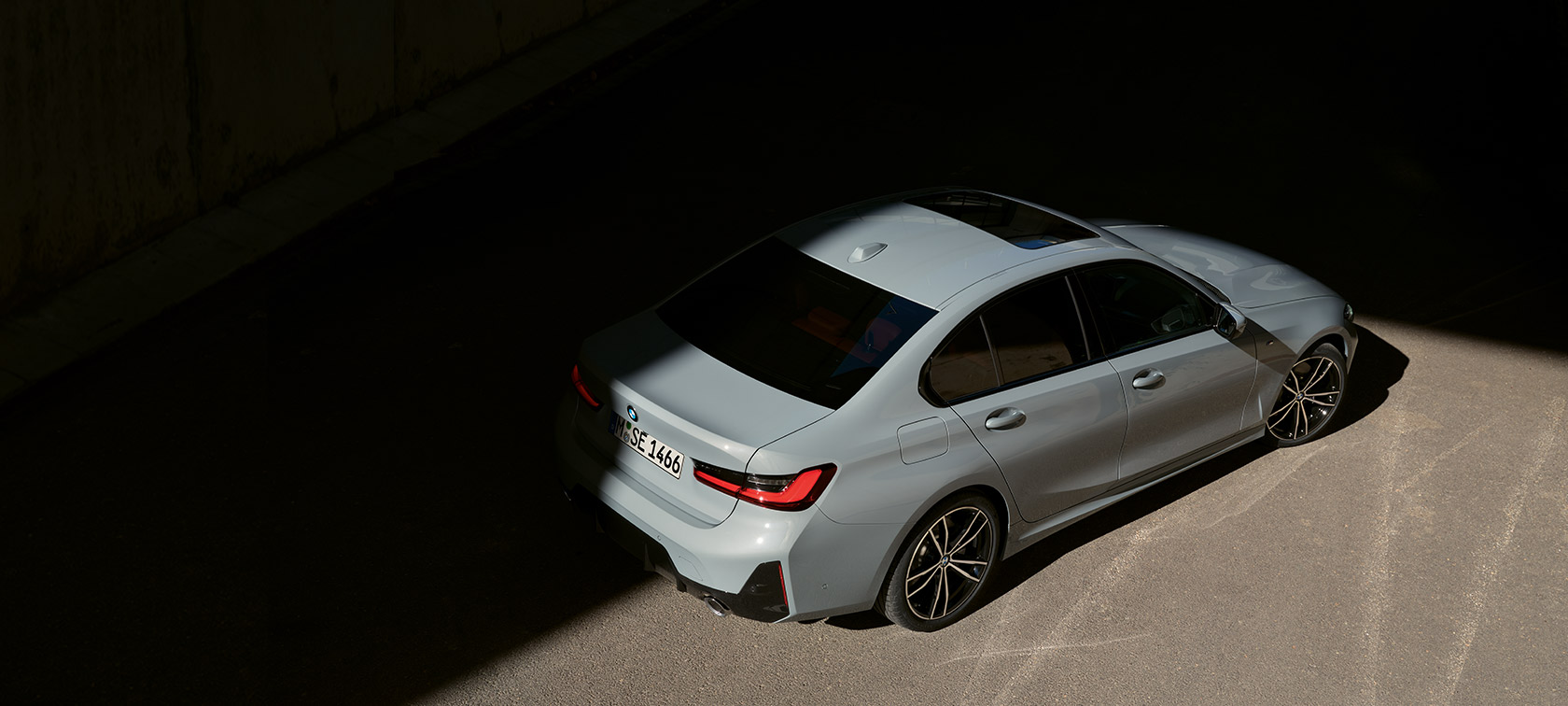 BMW 3 серії Sedan LCI G20 у кольорі Brooklyn Grey, вид ззаду з поворотом у три чверті з висоти пташиного польоту BMW 3 серії Sedan LCI G20, вид ззаду з поворотом у три чверті з висоти пташиного польоту
