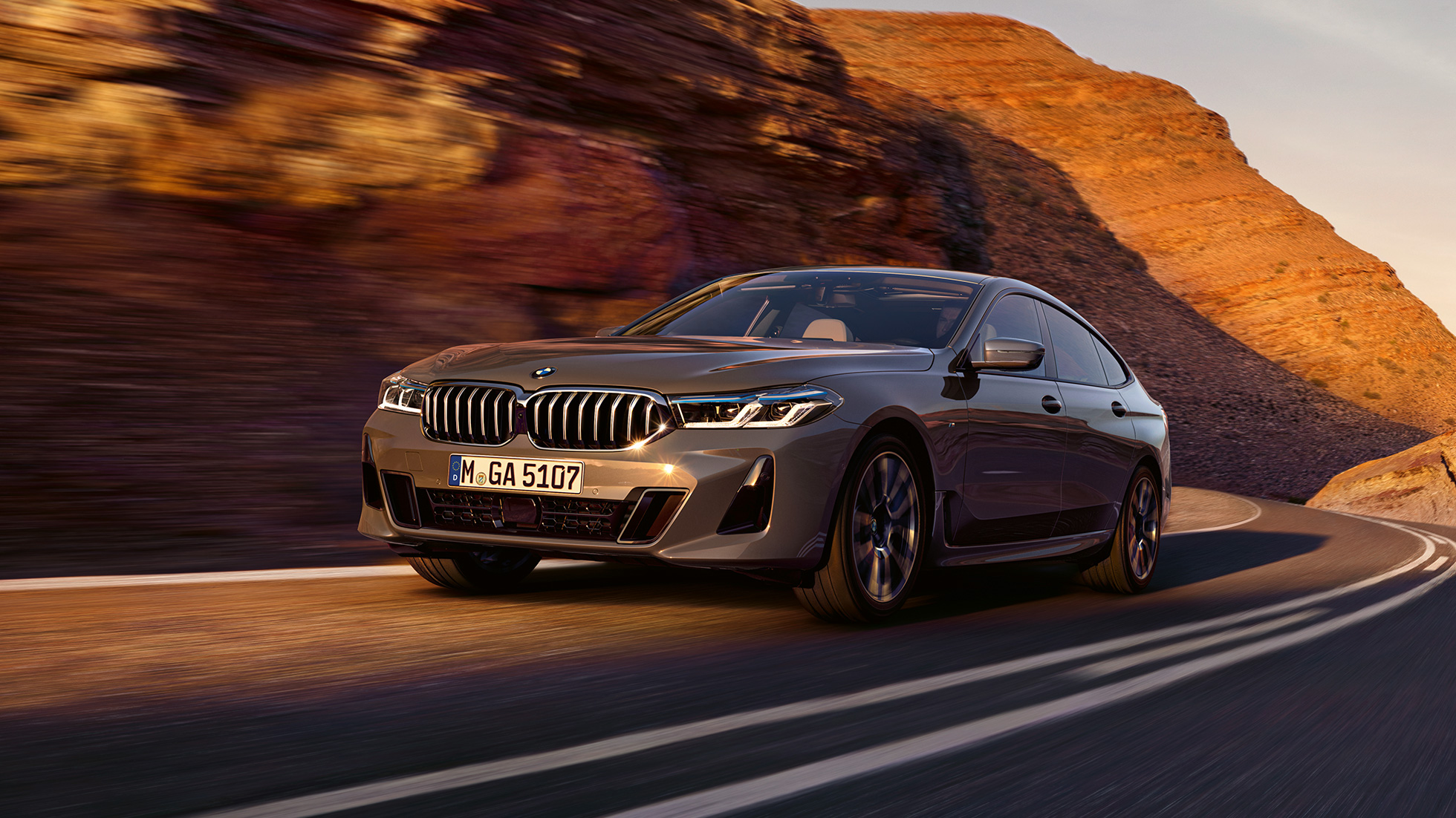 BMW 6 серії Gran Turismo G32 2020 BMW 6 серії Gran Turismo 640i xDrive G32 2020 у кольорі Bernina Grey рухається крізь природний ланлшафт, вид на три чверті спереду