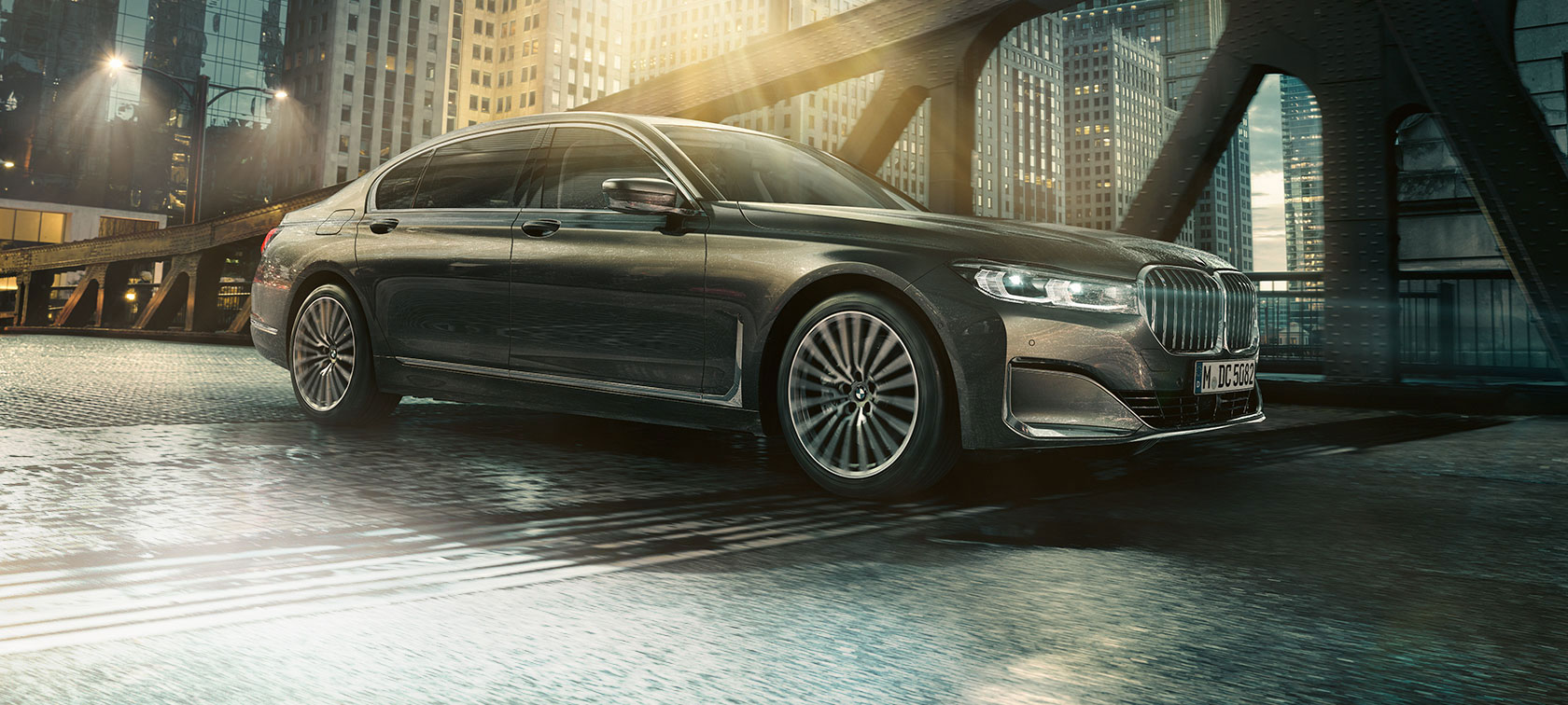 BMW 7 серії Седан: вид збоку BMW 7 серії Седан: вид збоку з відкритими дверима на тлі освітленого будівлі готелю