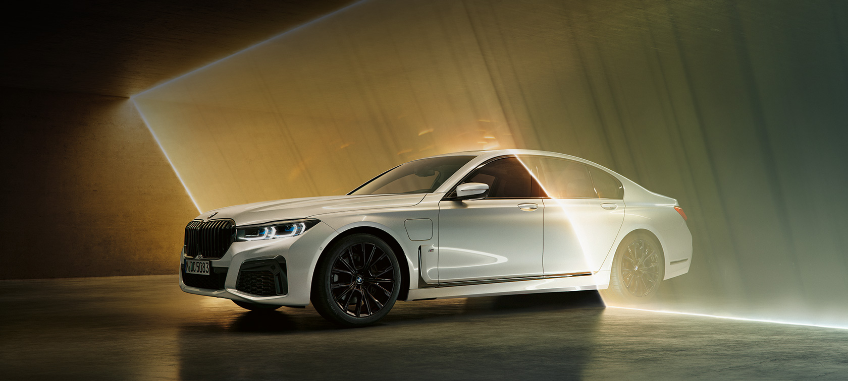 BMW 7 серії Седан білого кольору, вид спереду з поворотом в три чверті BMW 7 серії Седан: білий BMW, вид спереду з поворотом в три чверті в оточенні потоків світла