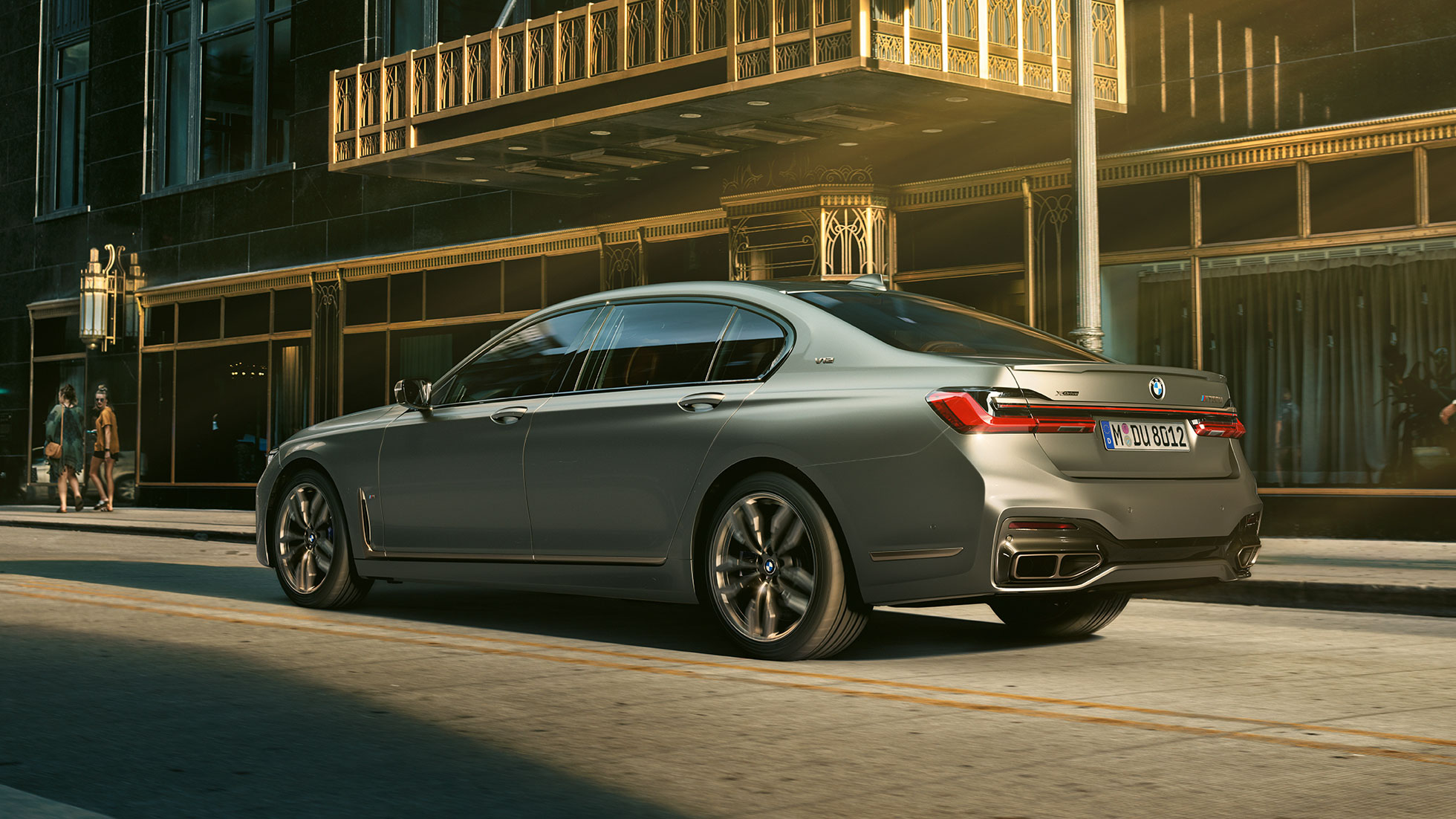 BMW M760Li xDrive з двигуном V12 BMW M760Li xDrive: вид ззаду збоку на тлі міських хмарочосів