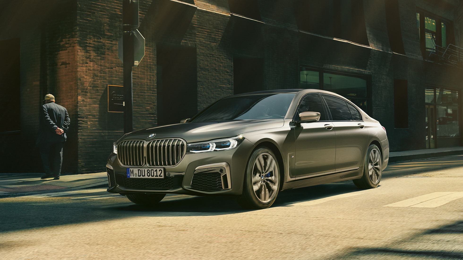 BMW M760Li xDrive в місті BMW M760Li xDrive: в русі по міських вулицях, вид ззаду збоку