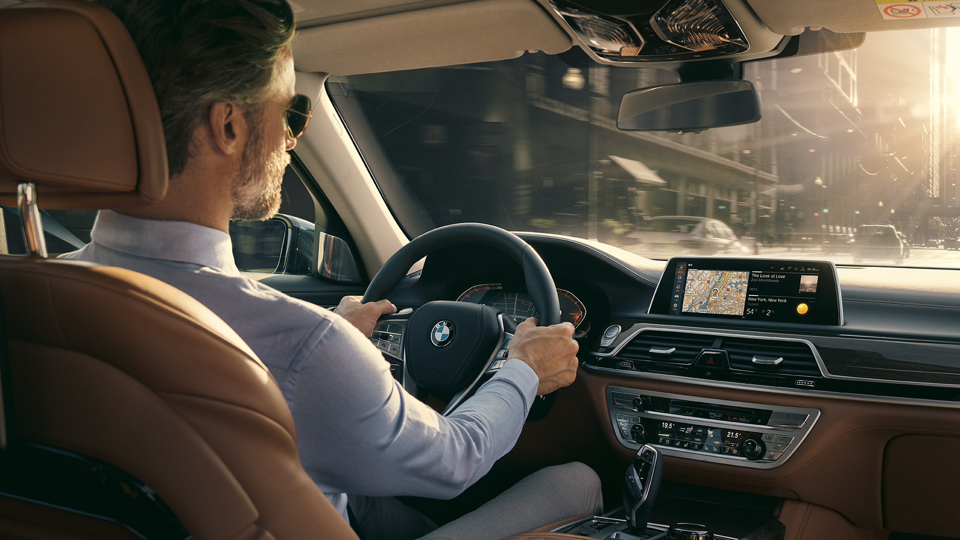 BMW 7 серії Седан: можливості підключення BMW 7 серії Седан: чоловік використовує можливості підключення BMW сидячи в автомобілі