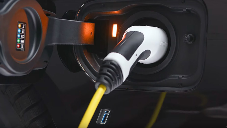 BMW плагин-гибрид, подключеный кабель для зараядки вблизи Плагин-гибрид BMW с подключенным кабелем для зарядки крупным планом