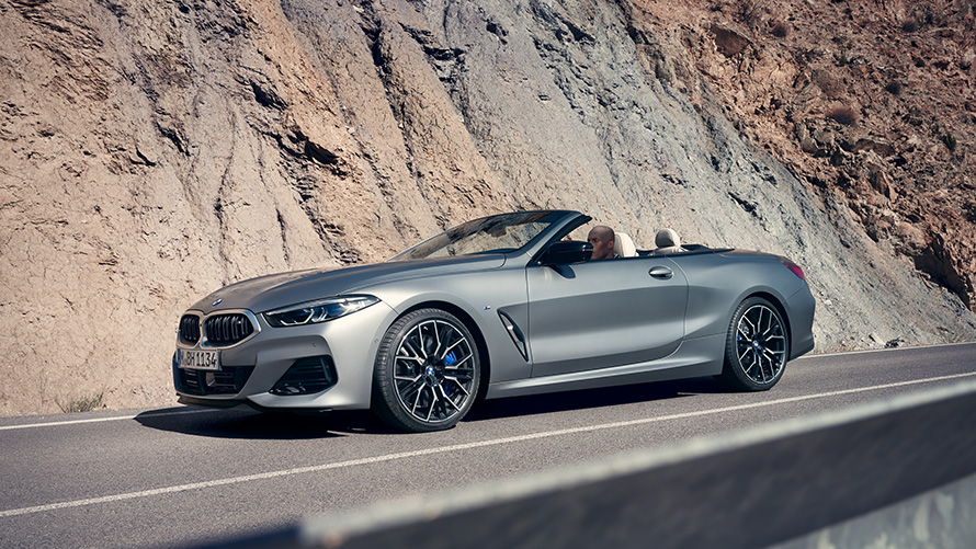 BMW 8 серії Cabrio G14 LCI Facelift 2022 у кольорі Individual Frozen Pure Grey metallic, вид збоку з відкритим дахом під час руху серед гір