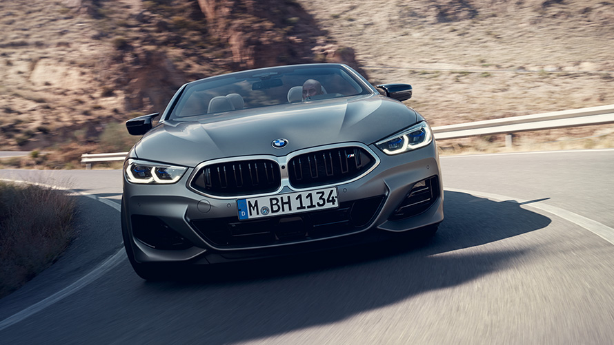 BMW 8 серії Cabrio Пакет M Sport G14 LCI Facelift 2022 M у кольорі Individual Frozen Pure Grey metallic, вид спереду під час руху