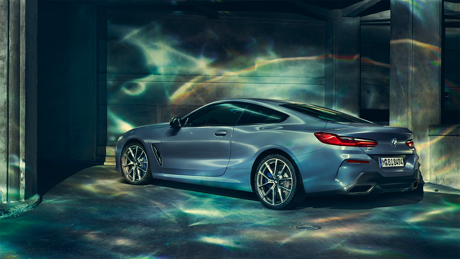 BMW 8 серії Купе, фото ззаду в три чверті Фото ззаду в три чверті BMW 8 серії Купе на фоні нічного міста.