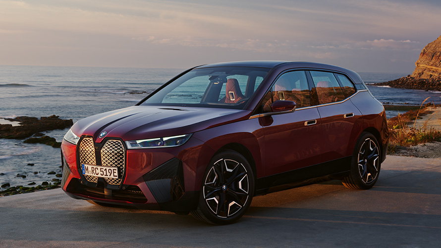 Електричний кросовер BMW iX i20 BMW iX xDrive50 аеродинамічний екстер’єр BMW iX i20 2021 електричний кросовер BMW iX xDrive50 у кольорі Aventurin Red вид збоку на екстер’єр