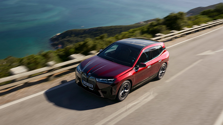 Електричний кросовер BMW iX i20 BMW iX xDrive50 BMW iX i20 2021, електричний кросовер BMW iX xDrive50 у кольорі Aventurin Red їде вулицею