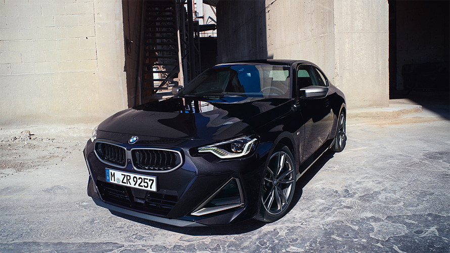BMW M240i xDrive Coupé G42 2021 у кольорі Black Sapphire металік, вид спереду в три чверті навпроти складу
