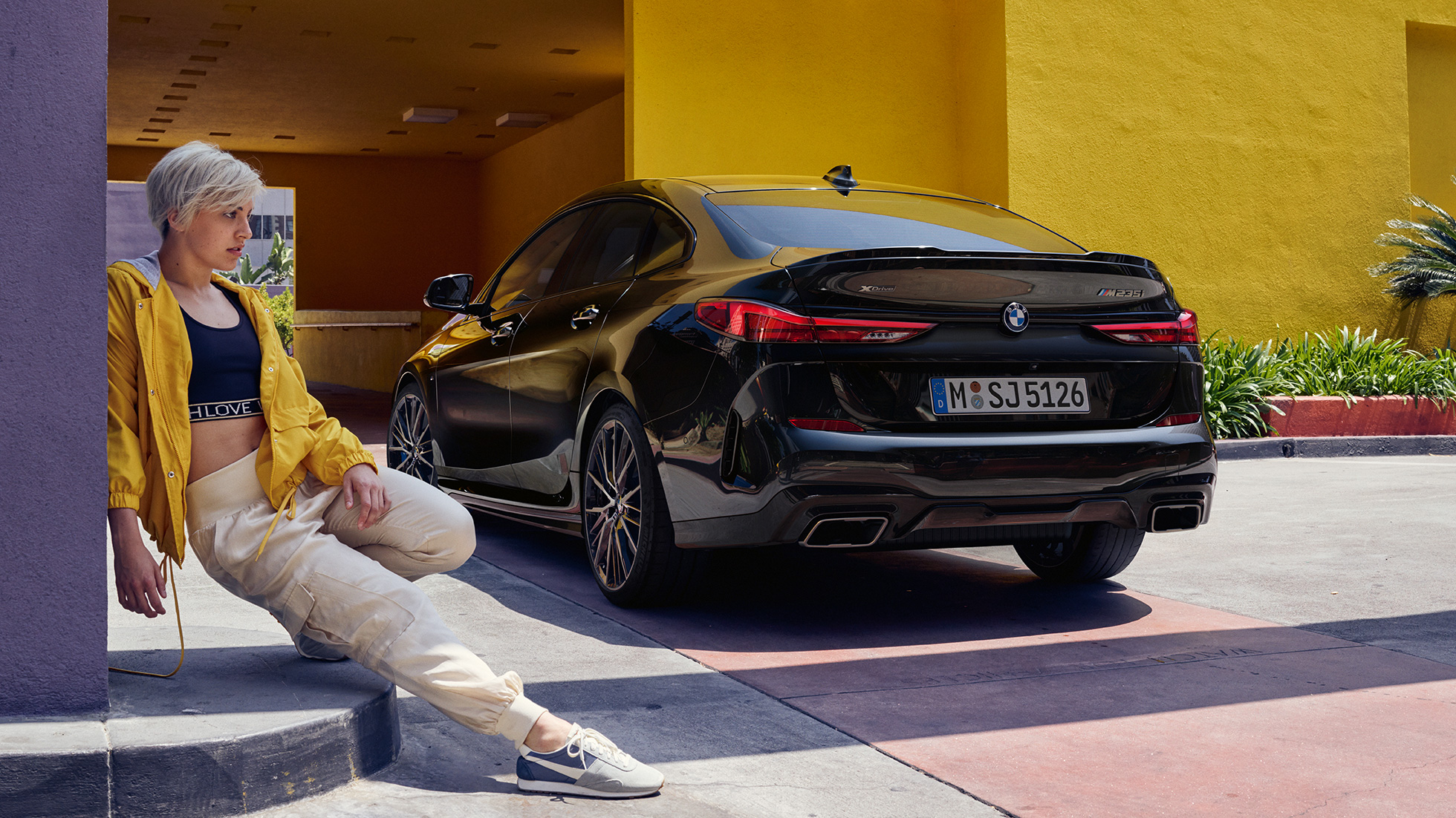Задня частина BMW M235i xDrive Gran Coupé Спортивна задня частина BMW M235i xDrive Gran Coupé 2020 Black Sapphire металік F44 вид ззаду з поворотом в три чверті