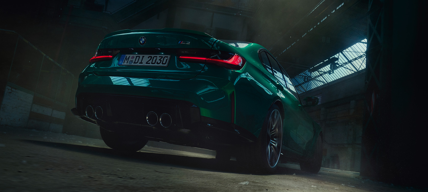 BMW M3 Competition G80 2020 вид на три чверті ззаду з нижньої перспективи BMW M3 Седан G80 2020 у кольорі Isle of Man green metallic, вид на три чверті ззаду з нижньої перспективи