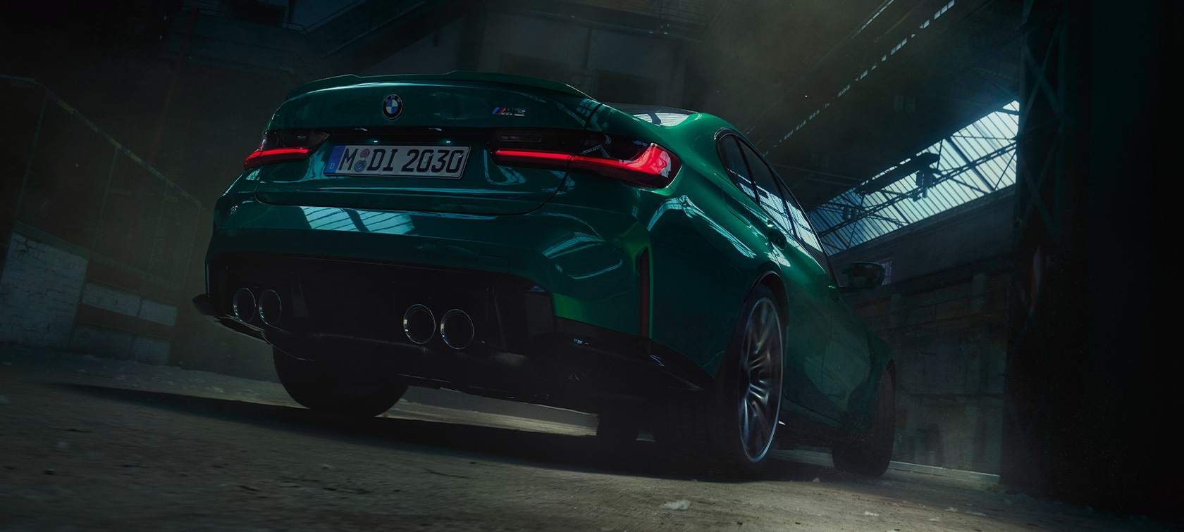 BMW M3 Competition G80 2020 вид ззаду в три чверті з нижньої перспективи BMW M3 Седан G80 2020 у кольорі Isle of Man Green металік, вид ззаду в три чверті з нижньої перспективи