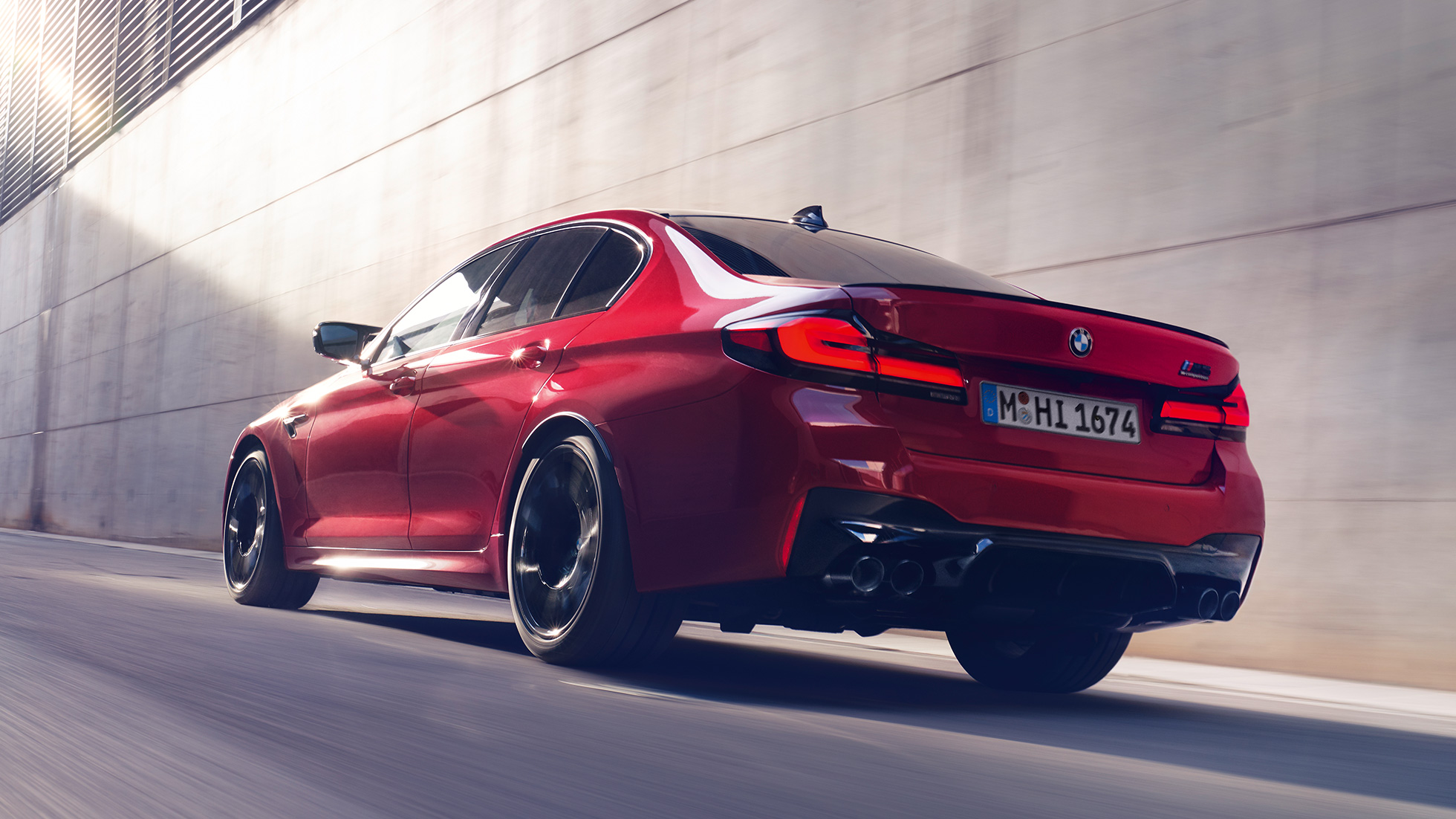 BMW M5 Competition F90 LCI 2020 вид на три чверті ззаду BMW M5 Competition F90 LCI 2020 кольору BMW Individual Imola Red вид на три чверті ззаду у русі