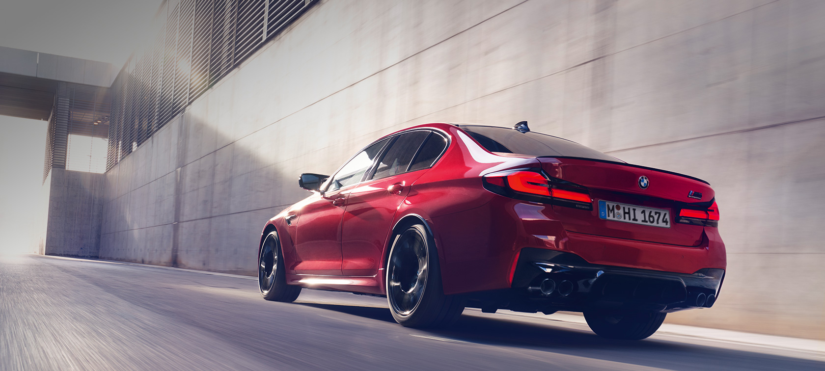 BMW M5 Competition F90 LCI 2020 кольору BMW Individual Imola Red вид на три чверті ззаду у русі