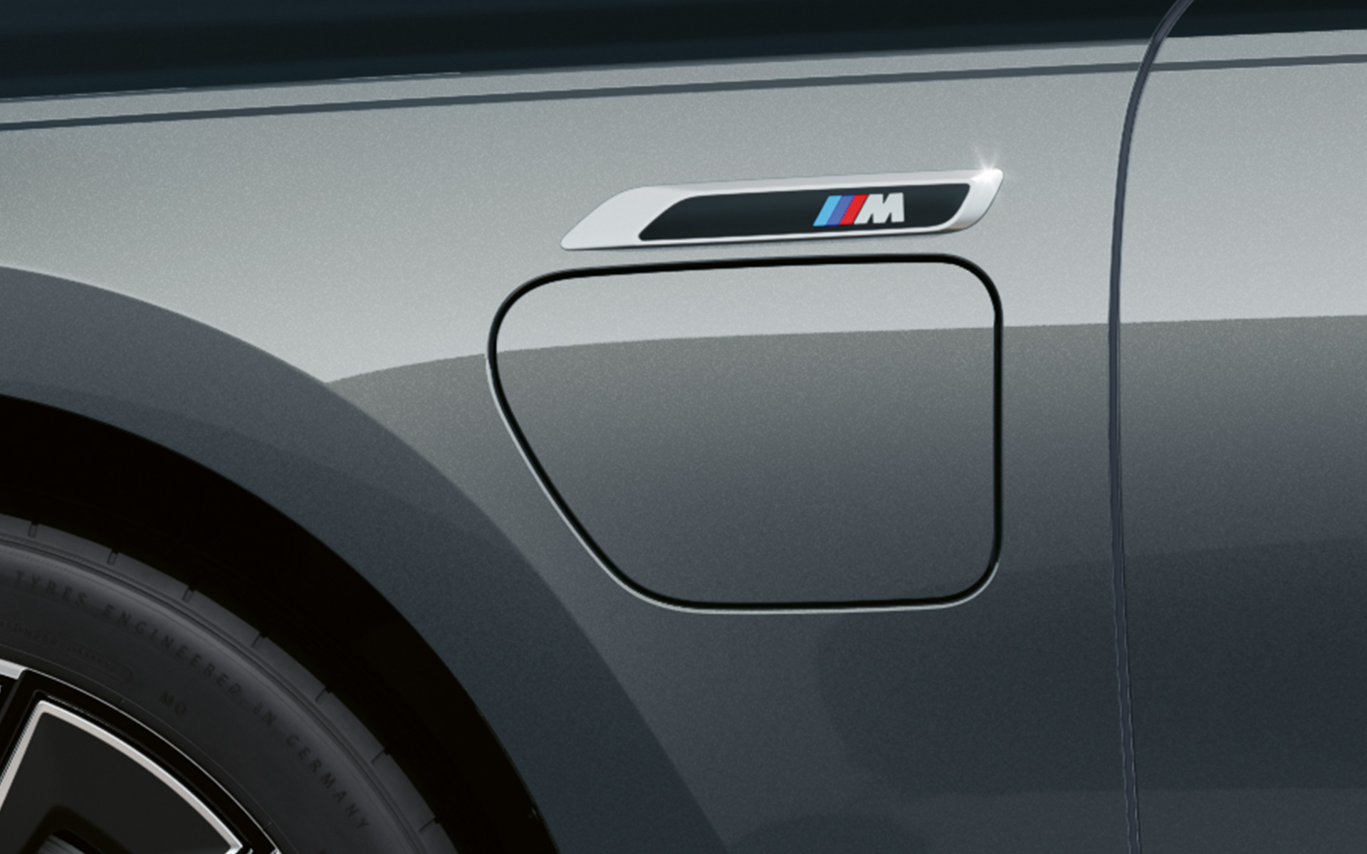 Логотип «М» BMW M760e xDrive Седан G70 Пакет M Performance двоколірне забарвлення BMW Individual Black Sapphire metallic BMW Individual Dravite Grey metallic великим планом вид збоку