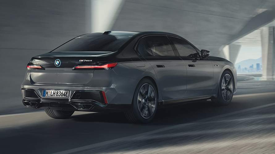BMW M760e xDrive Седан G70, пакет M Performance BMW M760e xDrive Седан G70 Пакет M Performance, двоколірне забарвлення BMW Individual Black Sapphire metallic BMW Individual Dravite Grey metallic, вид спереду в три чверті в русі на вулиці