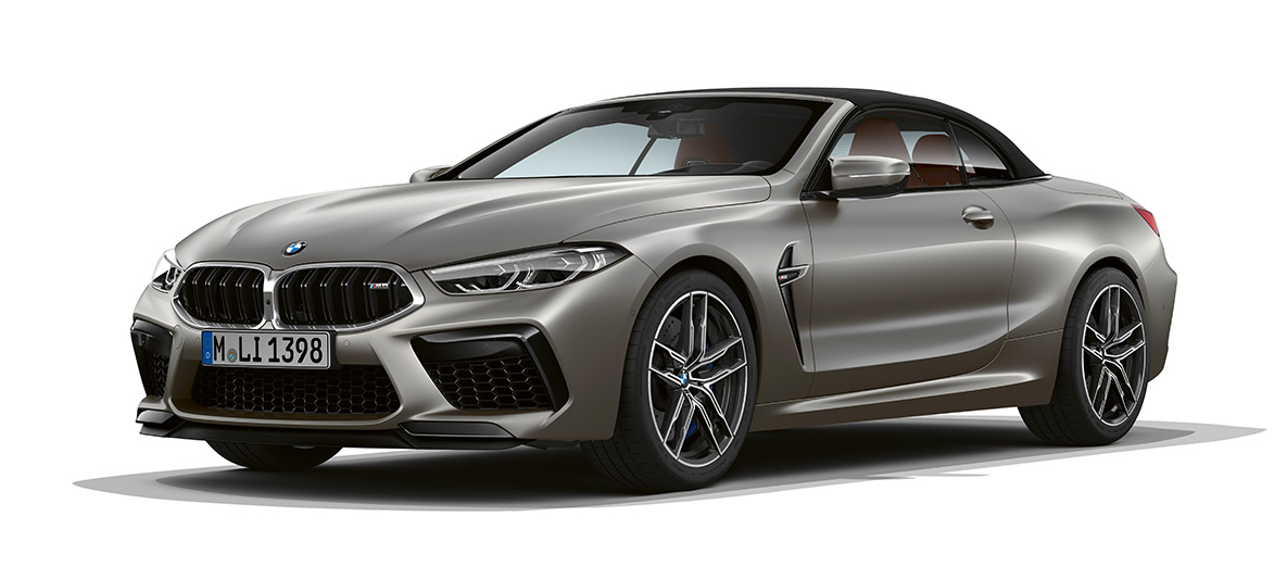 BMW M8 Кабріолет, вид збоку з поворотом в три чверті з передньою частиною. BMW M8 Кабріолет в Frozen Dark Silver, вид збоку з поворотом в три чверті з передньою частиною.