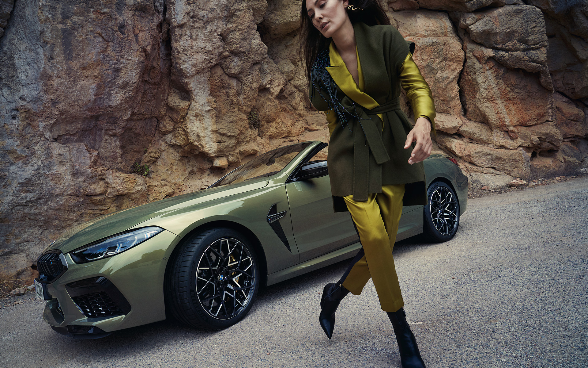 BMW M8 Competition Cabrio F91 LCI 2022 вид на три чверті спереду біля гірської стіни BMW M8 Competition Cabrio F91 LCI Facelift 2022 у кольорі BMW Individual Brass metallic, вид спереду на три чверті біля гірської поверхні та моделі
